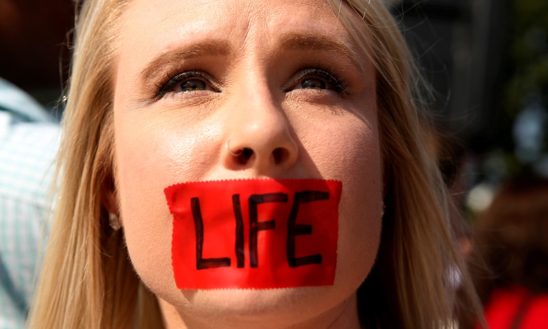 An anti abortion protester with tape over her mouth demonstrates outside the U S Supreme Court before the court handed a victory to abortion rights advocates striking down a Texas law imposing strict regulations on abortion doctors and facilities in Washington June 27 2016 <br/>REUTERS Kevin Lamarque